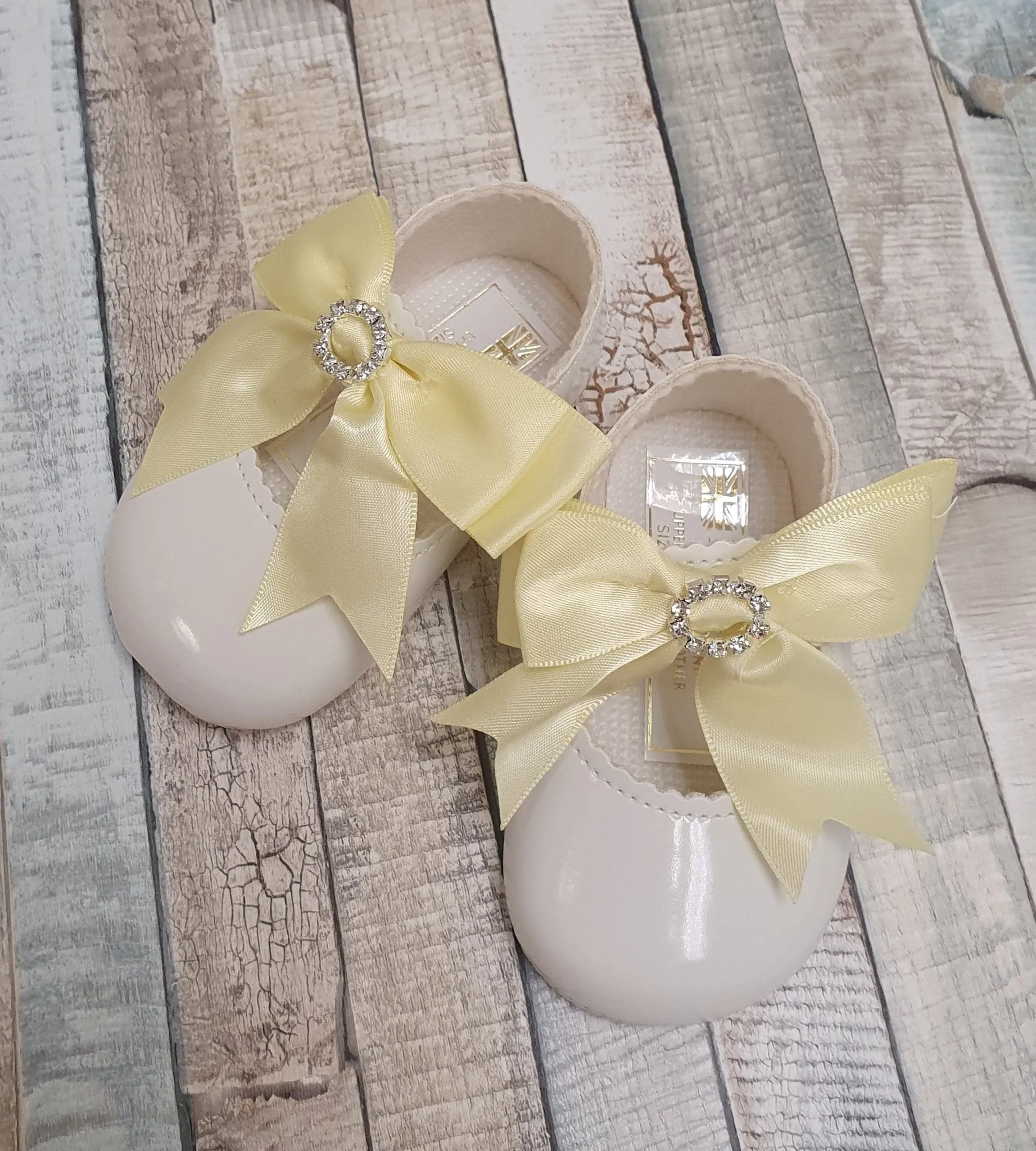 White Patent Soft Bottom Diamante Pram Shoe With Lemon Bow